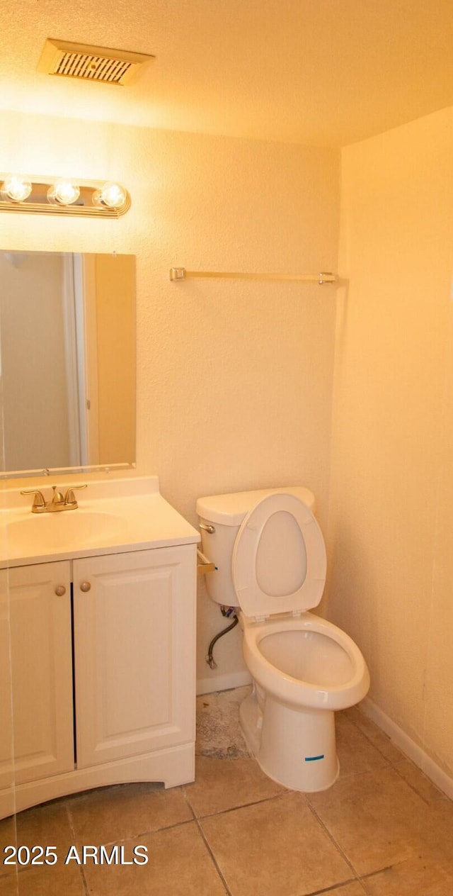 bathroom featuring tile patterned floors, vanity, and toilet