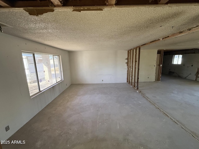 empty room featuring a textured ceiling and a healthy amount of sunlight