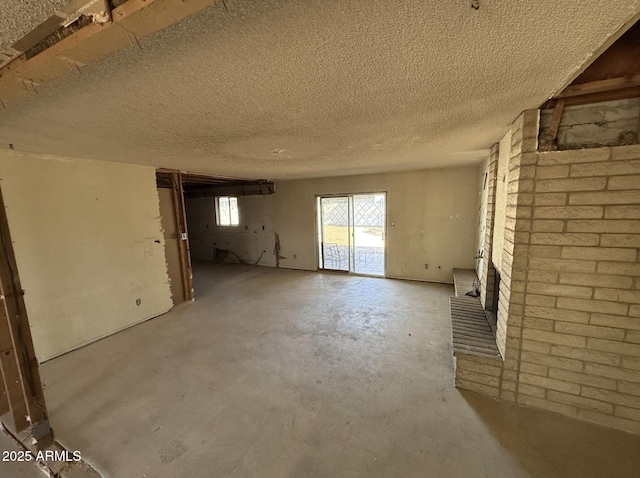 unfurnished living room featuring a textured ceiling and concrete floors