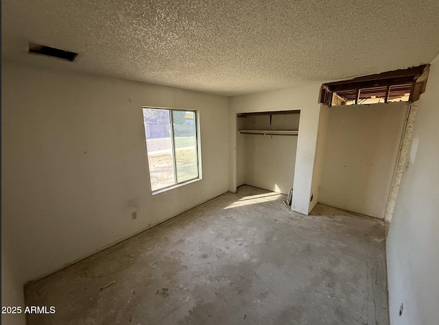 unfurnished bedroom with a textured ceiling and a closet