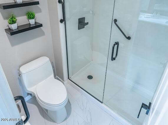 bathroom with toilet and an enclosed shower