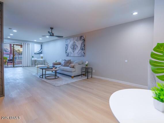 living room with ceiling fan and light hardwood / wood-style floors