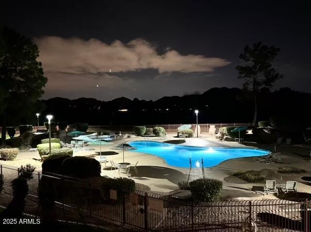 pool at twilight featuring a patio area