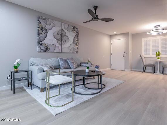 living room featuring light hardwood / wood-style flooring and ceiling fan