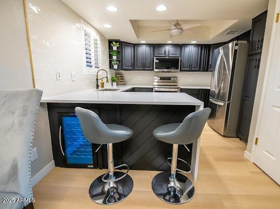 kitchen featuring appliances with stainless steel finishes, sink, a breakfast bar area, and kitchen peninsula