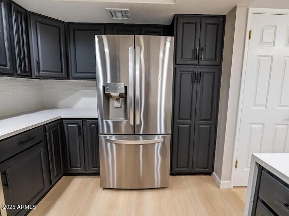 kitchen with light wood-type flooring and stainless steel refrigerator with ice dispenser