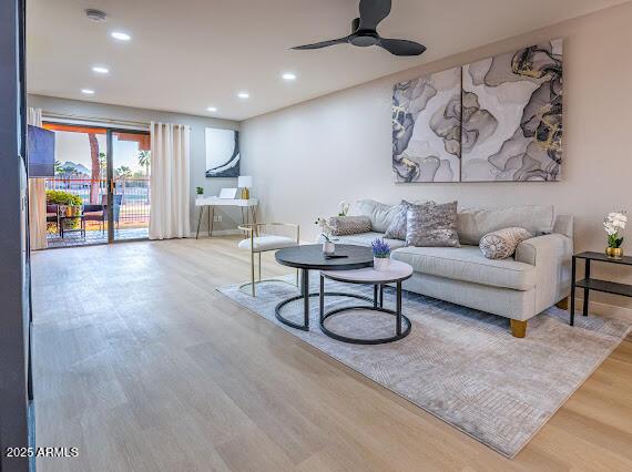 living room featuring ceiling fan and hardwood / wood-style floors