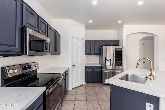 kitchen featuring light tile patterned floors, decorative backsplash, stainless steel appliances, a sink, and recessed lighting