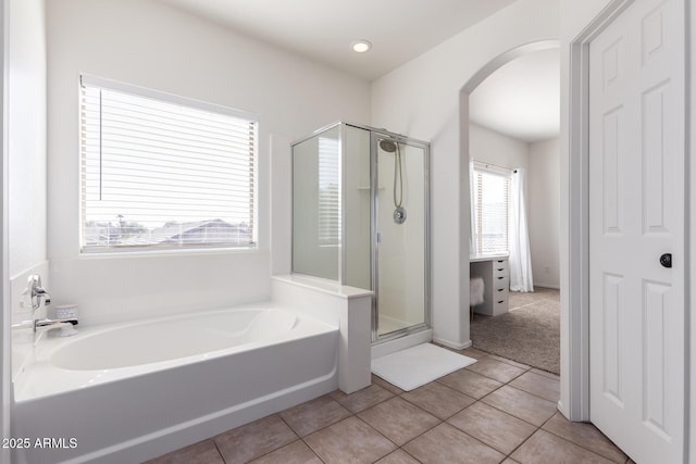 bathroom featuring a stall shower, tile patterned flooring, and a garden tub