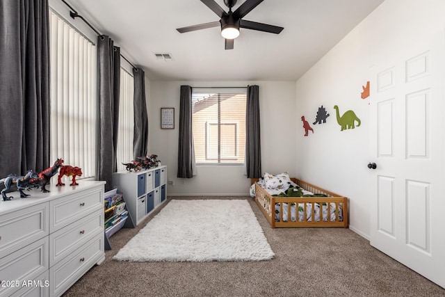 carpeted bedroom featuring baseboards, visible vents, and a ceiling fan