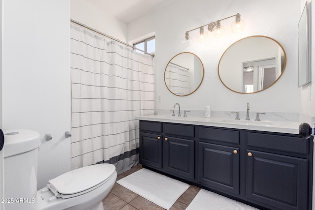 full bath with toilet, double vanity, a sink, and tile patterned floors