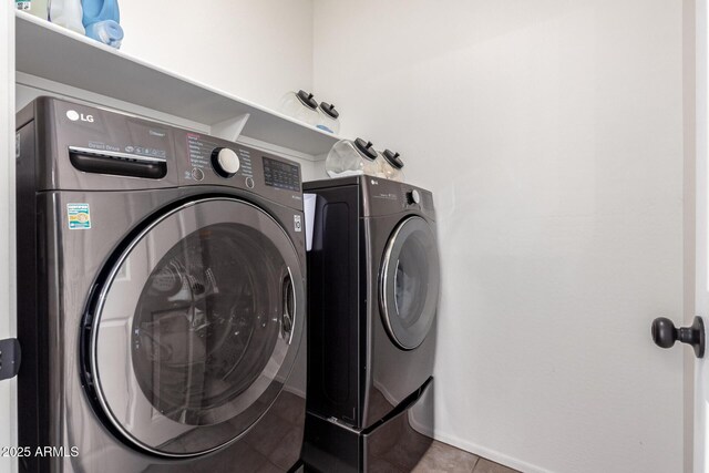 washroom featuring laundry area, washer and clothes dryer, and tile patterned floors