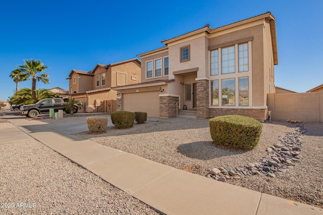 view of front of house with a garage, fence, stone siding, concrete driveway, and stucco siding