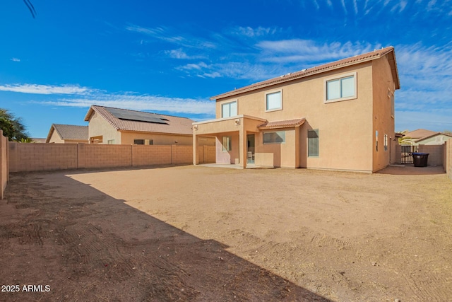 rear view of house with a patio area, a fenced backyard, and stucco siding