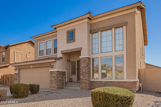 view of front facade with stone siding, fence, an attached garage, and stucco siding