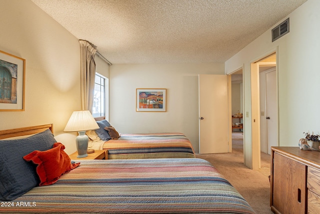 carpeted bedroom featuring a textured ceiling