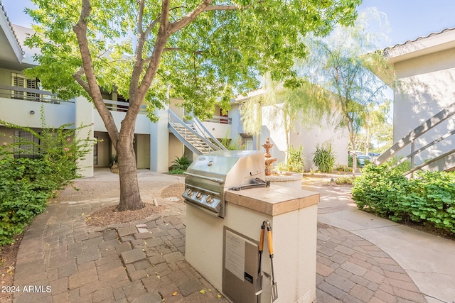 view of patio featuring exterior kitchen and a grill