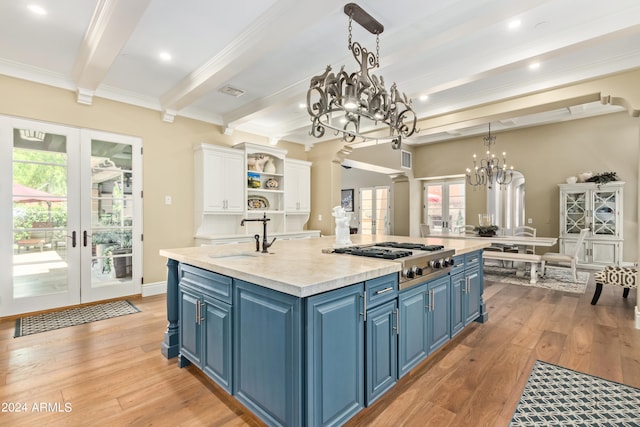 kitchen featuring stainless steel gas stovetop, blue cabinetry, french doors, and sink