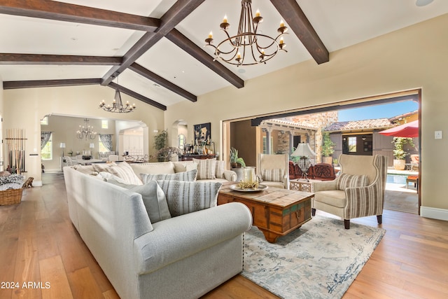 living room featuring a wealth of natural light, light hardwood / wood-style flooring, and lofted ceiling with beams