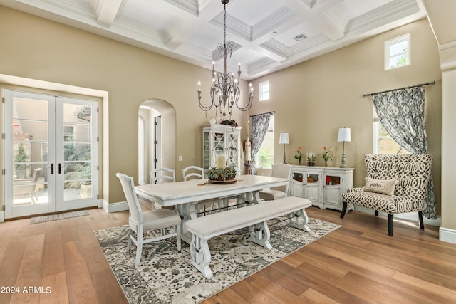 dining room featuring french doors, light hardwood / wood-style flooring, a chandelier, and a healthy amount of sunlight