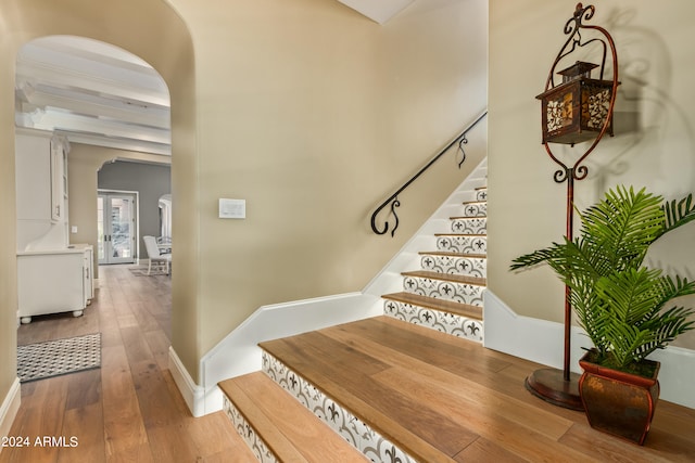 stairway featuring hardwood / wood-style flooring and beamed ceiling