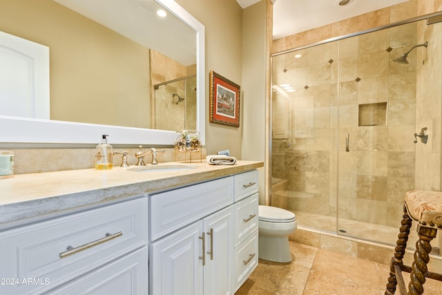 bathroom featuring toilet, an enclosed shower, and vanity