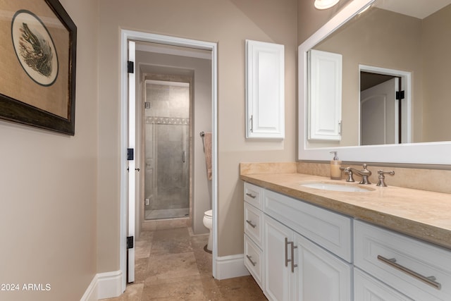 bathroom with toilet, a shower with door, and vanity