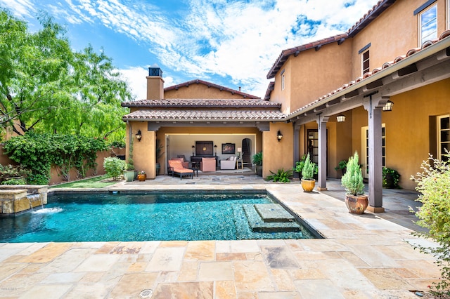 rear view of property with a patio area, a pool with hot tub, and pool water feature