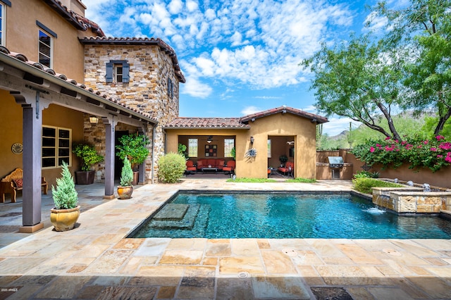 view of pool with pool water feature, a patio area, an in ground hot tub, and exterior kitchen