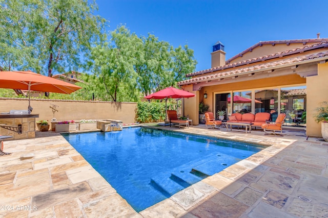 view of pool with an outdoor living space and a patio area