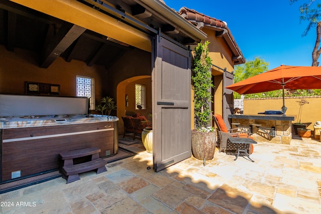 view of patio / terrace featuring an outdoor bar and a hot tub