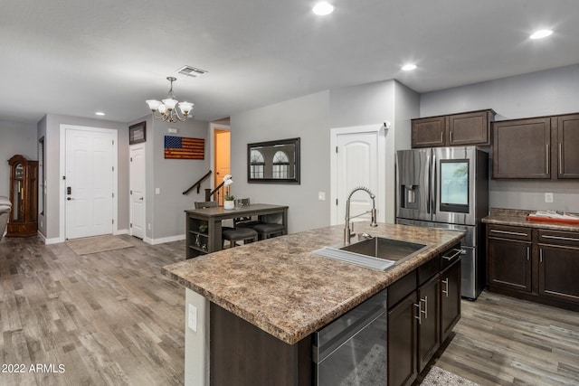 kitchen featuring dark brown cabinetry, light wood-style floors, appliances with stainless steel finishes, and a sink