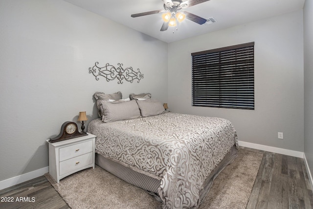 bedroom with visible vents, baseboards, and wood finished floors