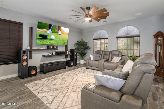 living area with ceiling fan, visible vents, baseboards, and wood finished floors