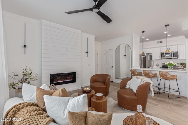 5401 E Van Buren St Unit 1088, Phoenix, AZ 85008 - living area featuring light wood finished floors, a ceiling fan, a large fireplace, and recessed lighting