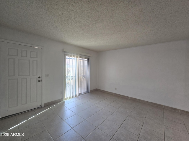 tiled spare room with a textured ceiling