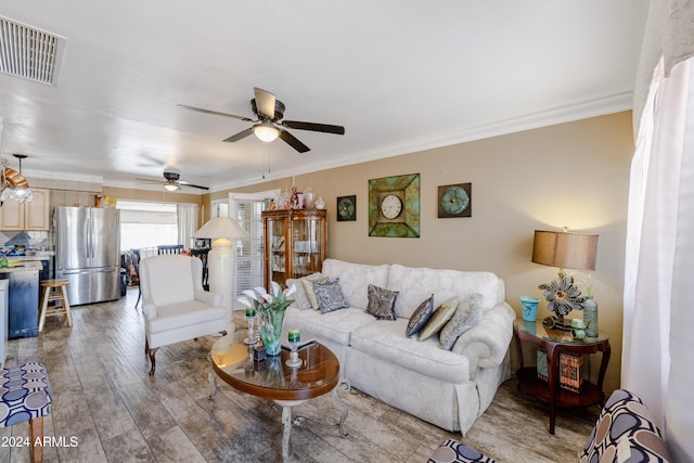 living room with ceiling fan, ornamental molding, and hardwood / wood-style floors