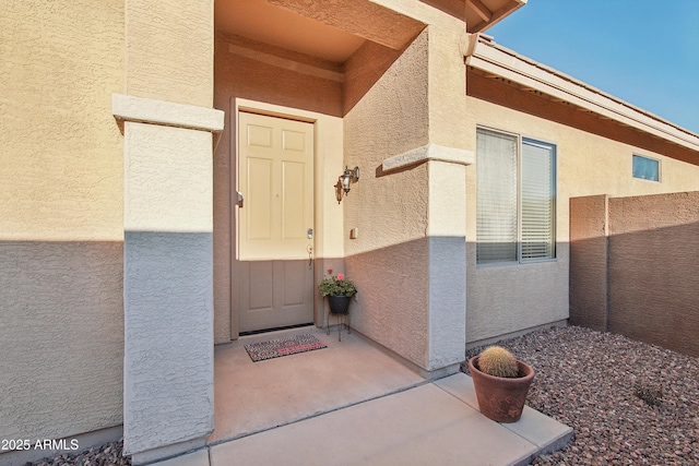 view of exterior entry with a patio area