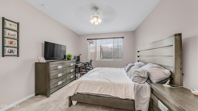 bedroom featuring light colored carpet, baseboards, and ceiling fan
