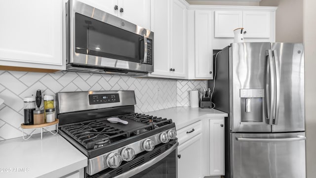 kitchen with stainless steel appliances, light countertops, white cabinets, and decorative backsplash