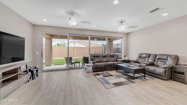 living area with ceiling fan, light wood-type flooring, healthy amount of natural light, and recessed lighting