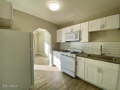 1620 E Palm Ln, Phoenix, AZ 85006 - kitchen with white appliances, dark countertops, a sink, and decorative backsplash