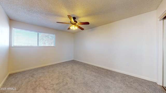 carpeted spare room featuring a textured ceiling, baseboards, and a ceiling fan