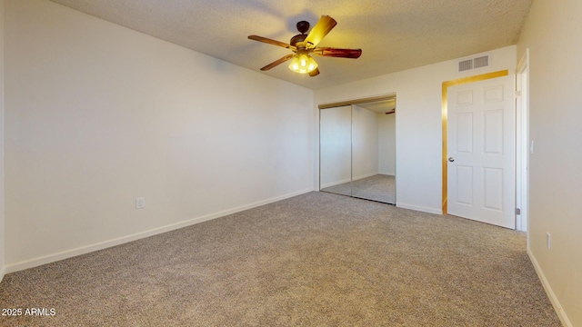 unfurnished bedroom with carpet, a closet, visible vents, a textured ceiling, and baseboards