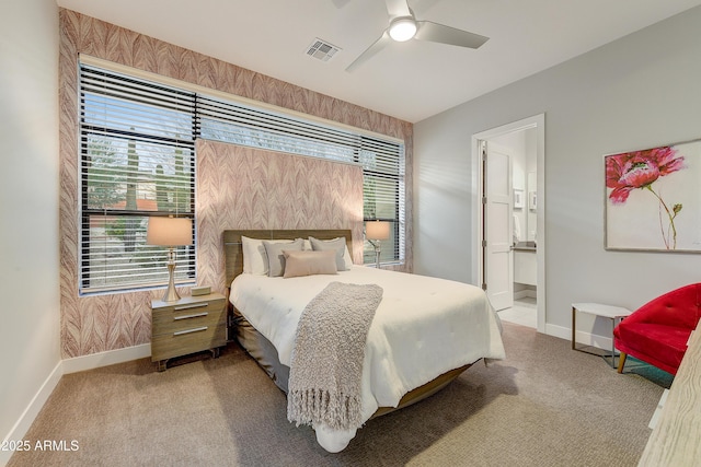 bedroom with ensuite bathroom, ceiling fan, light carpet, and multiple windows