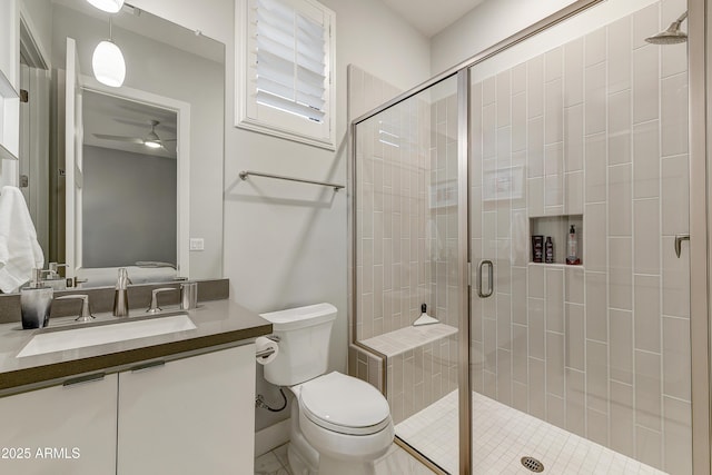 bathroom with vanity, toilet, an enclosed shower, and ceiling fan