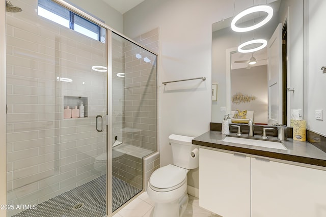 bathroom featuring tile patterned flooring, vanity, toilet, and a shower with shower door