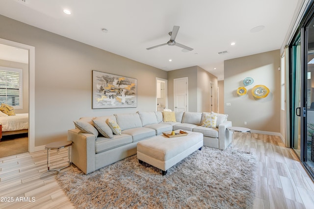 living room featuring ceiling fan and light hardwood / wood-style flooring