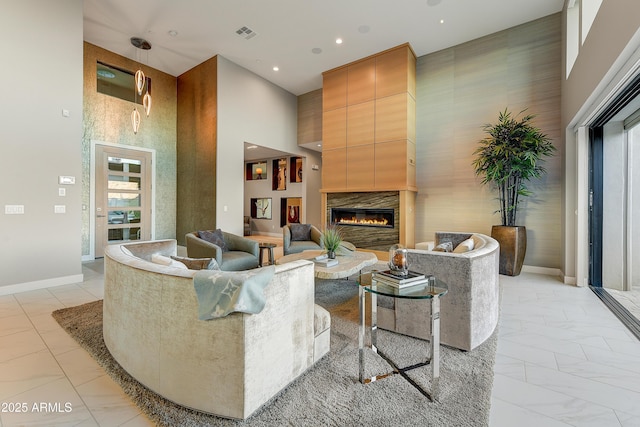 living room with a towering ceiling and a fireplace