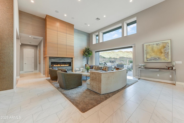 living room with a fireplace and a high ceiling